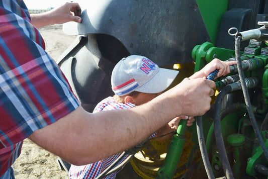 A father and son use outback hydraulic hose markers on their tractor