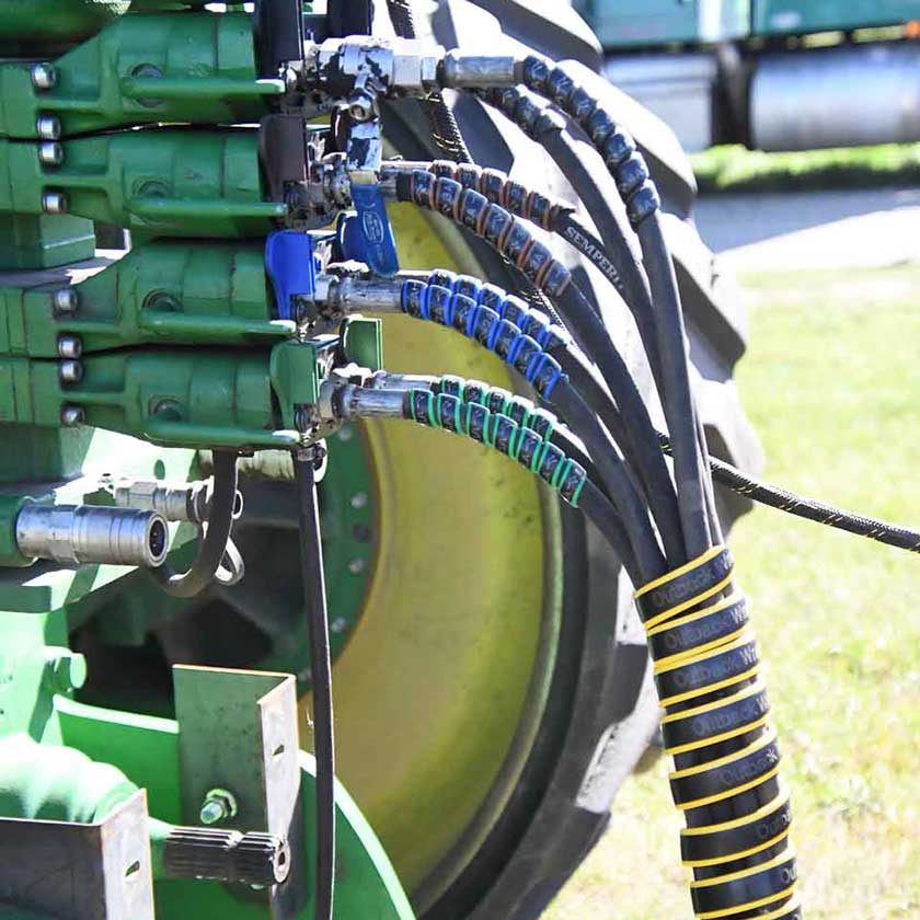 The Hydraulic Hose Marker Starter Pack 1 on the hydraulic lines of an implement.