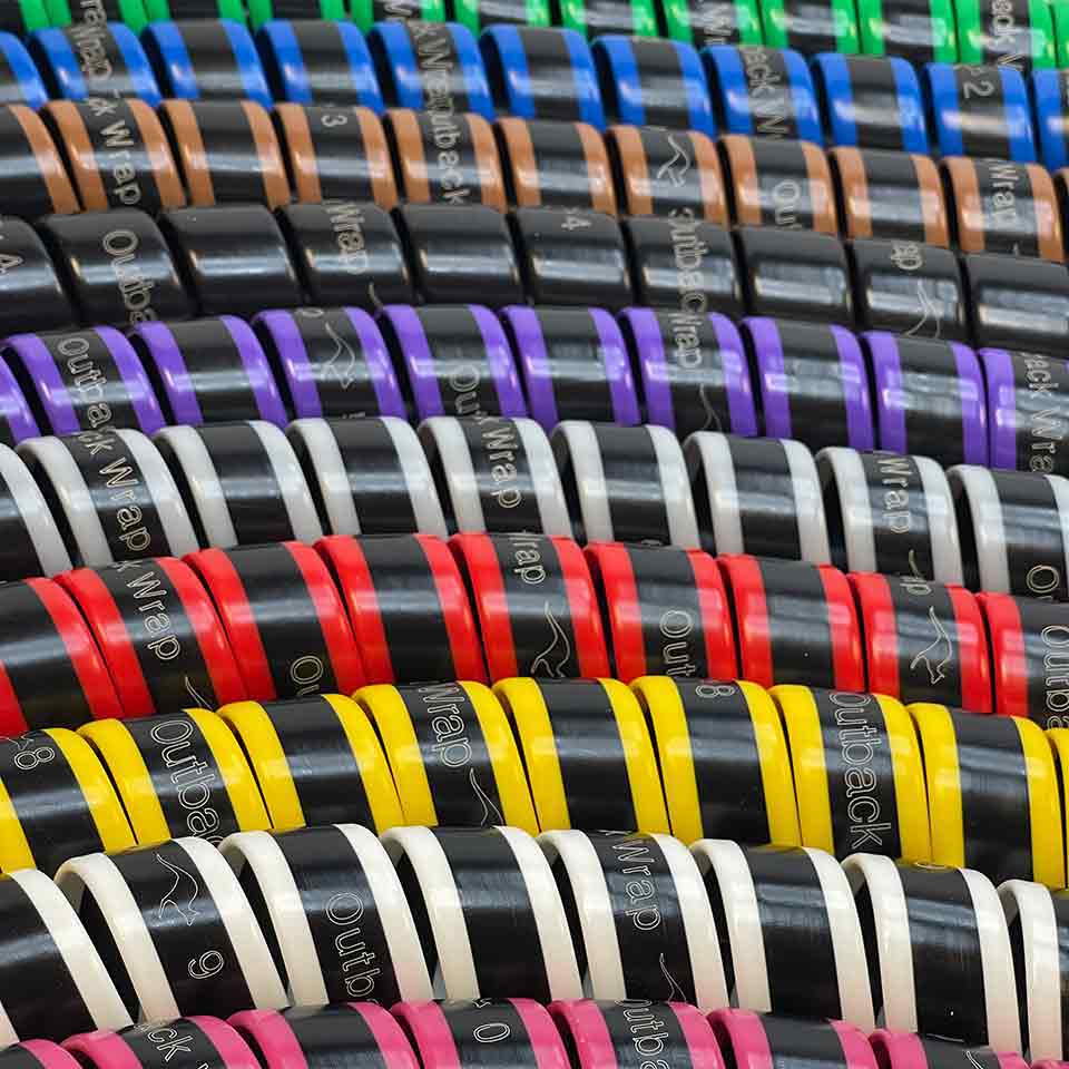 Outback Wrap hydraulic hose tamers shown in green, blue, yellow and red, pink, brown, black, purple, grey and white